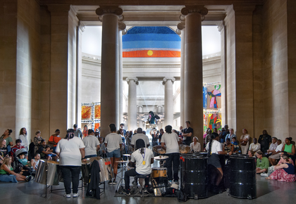 Image of mangrove steel pan band playing to an audience in the Duveens at Tate Britain